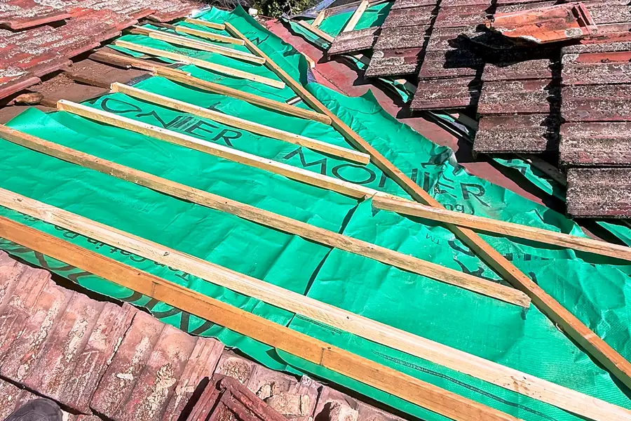 New sarking and battens laid under existing tiles before they are relaid