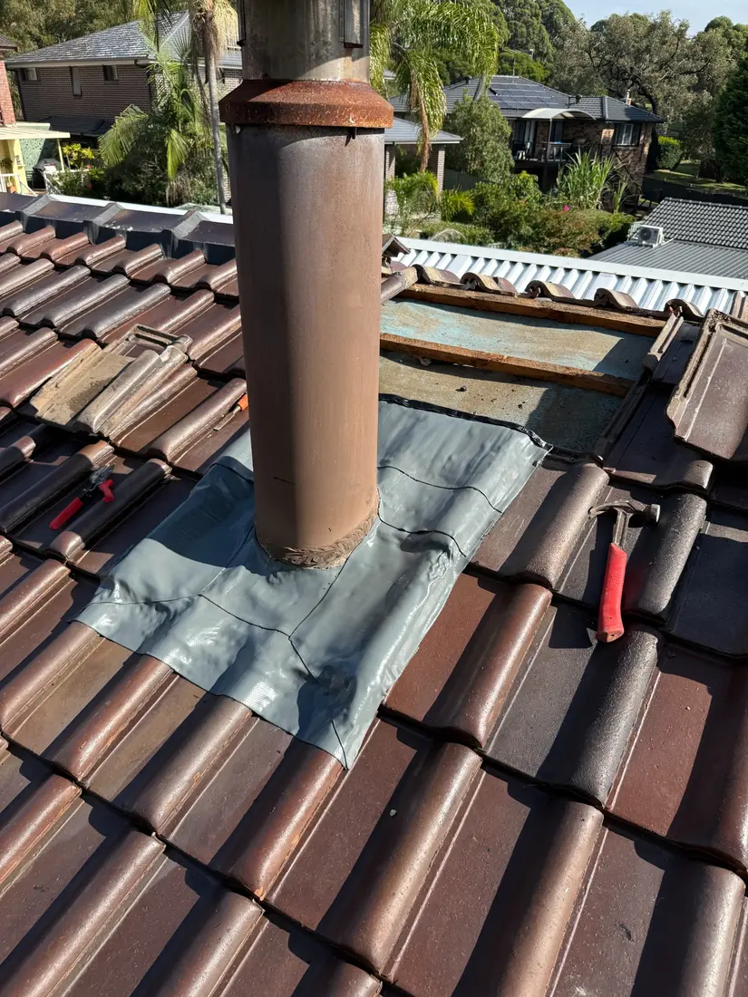 Chimney flashing on a tile roof in Sydney being repaired after a leak was traced to it