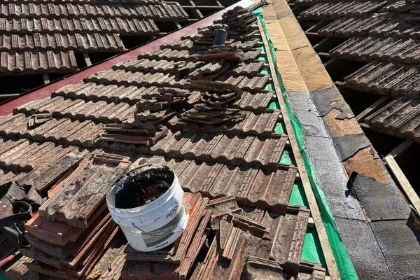 Roof tiles lifted and stacked during a sarking and batten repair