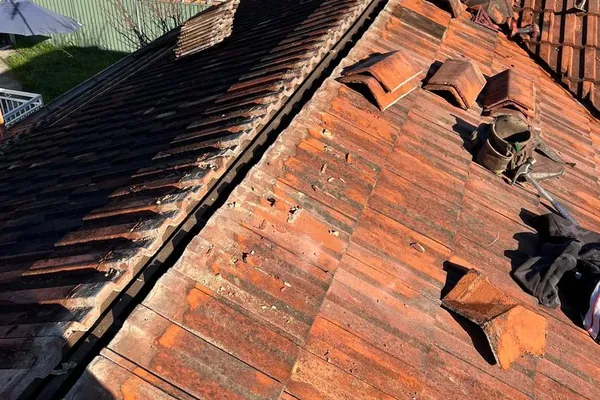 Tile roof repair in progress with tiles lifted